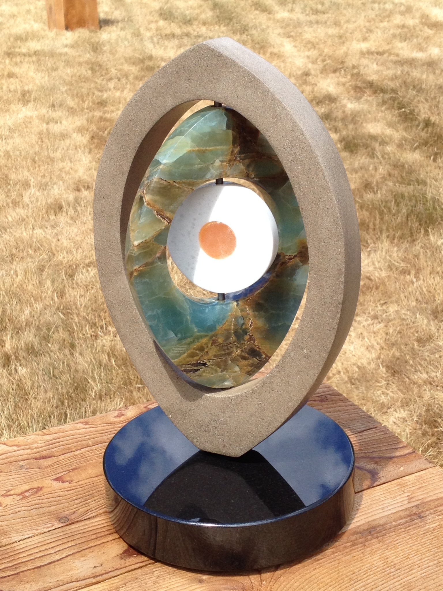 “IO”, limestone, blue/green onyx, white marble, orange calcite, 20” high